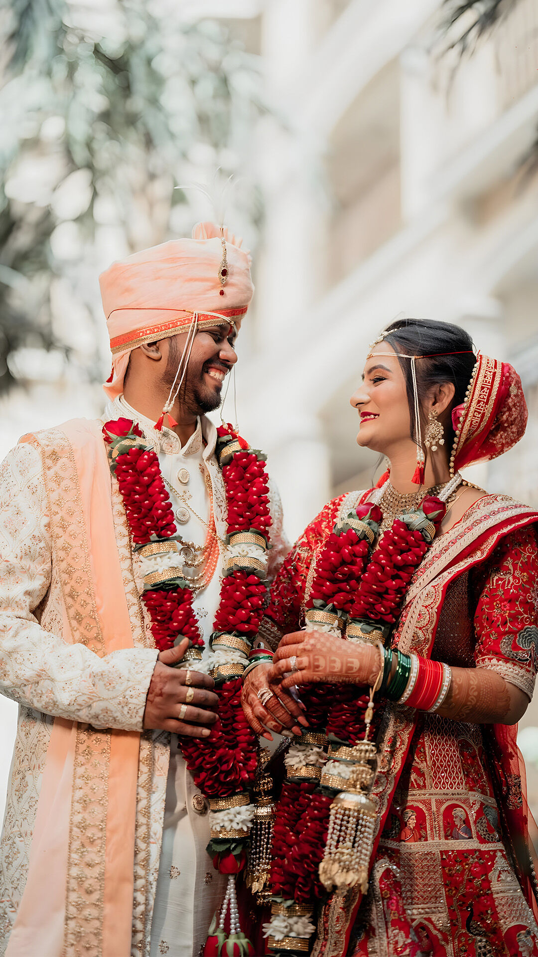 A Sindhi bride and groom sharing a happy moment, smiling and enjoying their vibrant wedding festivities.